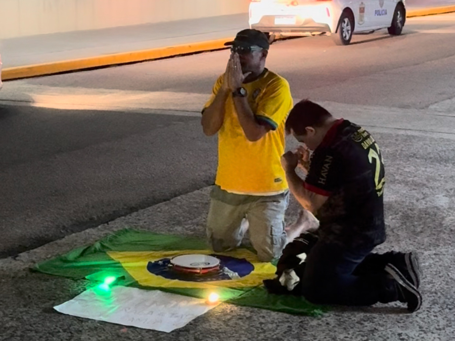 Torcedores se ajoelham no asfalto e fazem oração por Neymar durante embarque da Seleção Brasileira