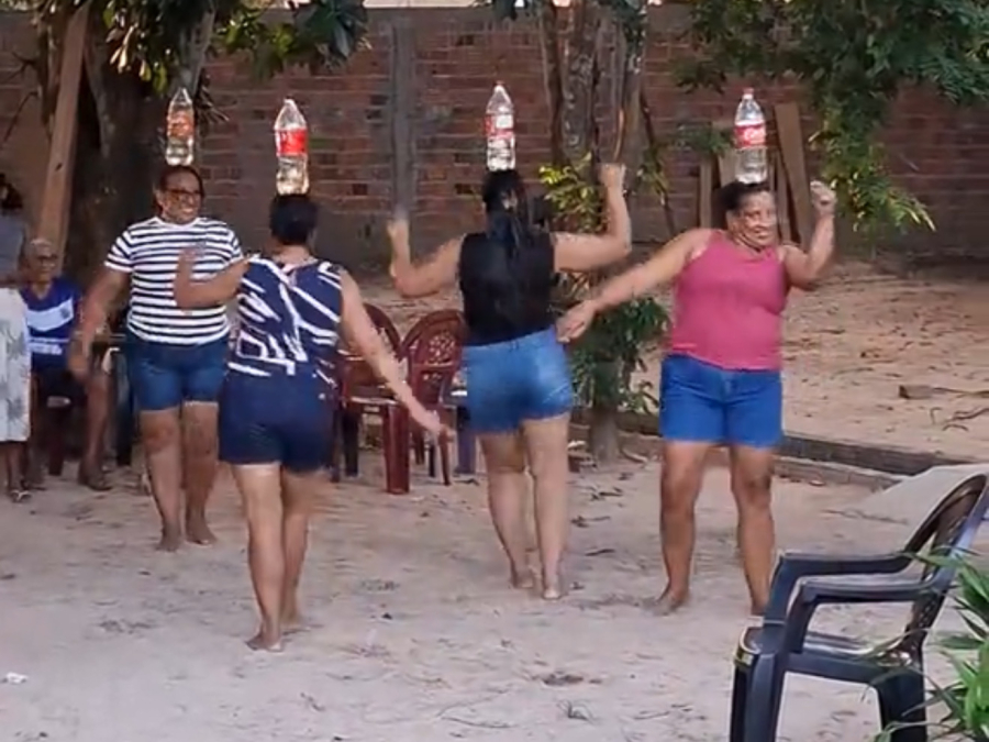 Mulheres dançam reggae com garrafas na cabeça durante reunião de família no Maranhão
